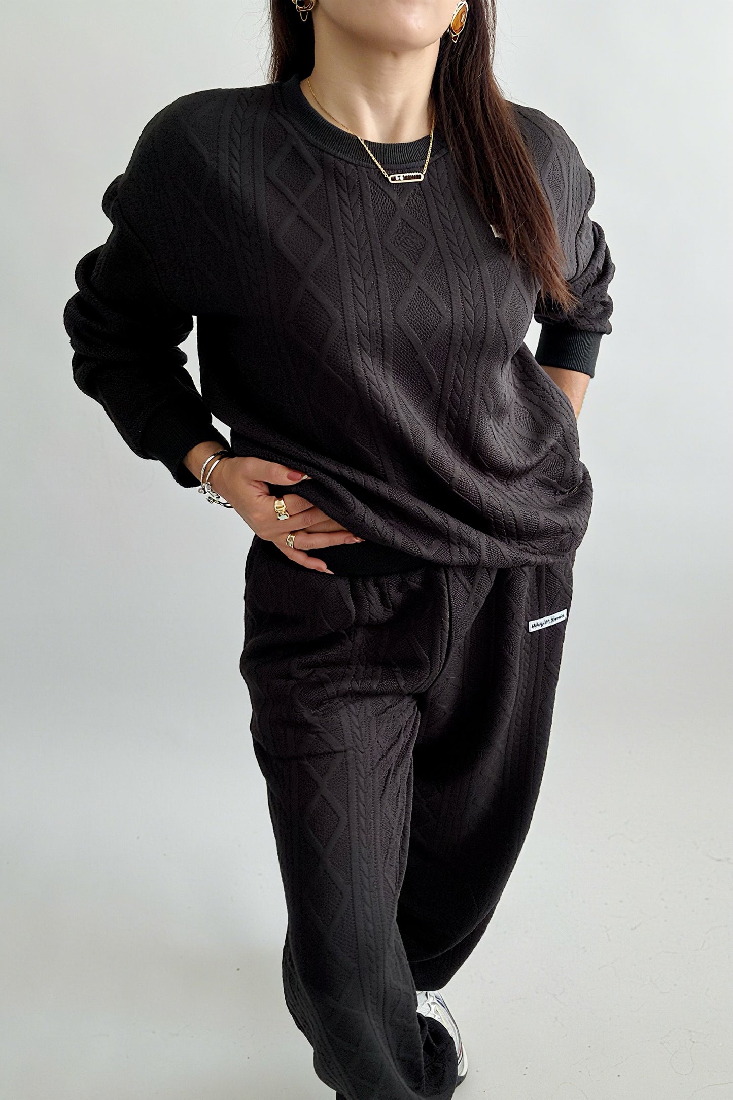 Ensemble femme 2 pièces composé d’un sweat-shirt texturé à manches longues et d’un pantalon assorti, disponible en blanc et noir, style décontracté et élégant.