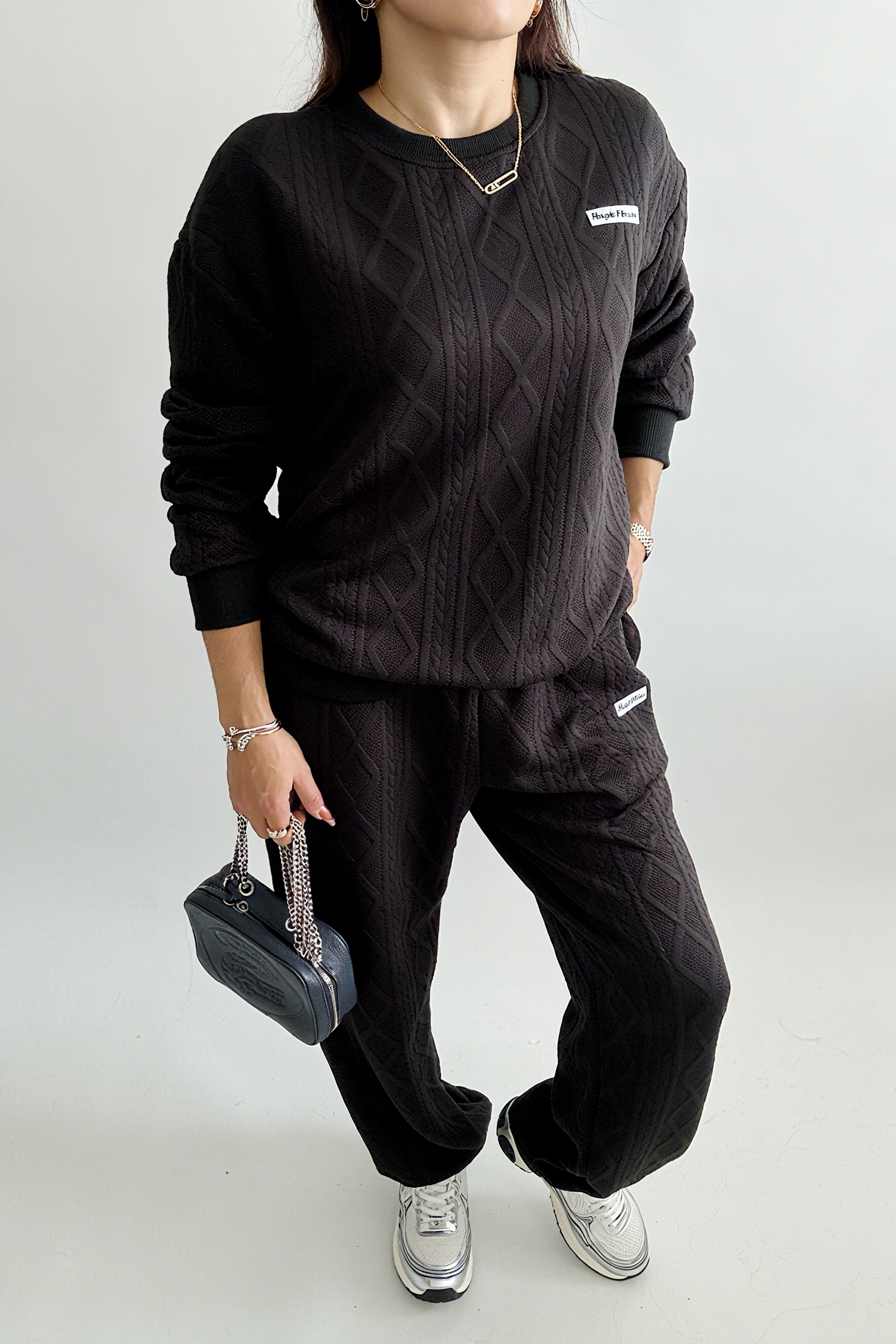 Ensemble femme 2 pièces composé d’un sweat-shirt texturé à manches longues et d’un pantalon assorti, disponible en blanc et noir, style décontracté et élégant.