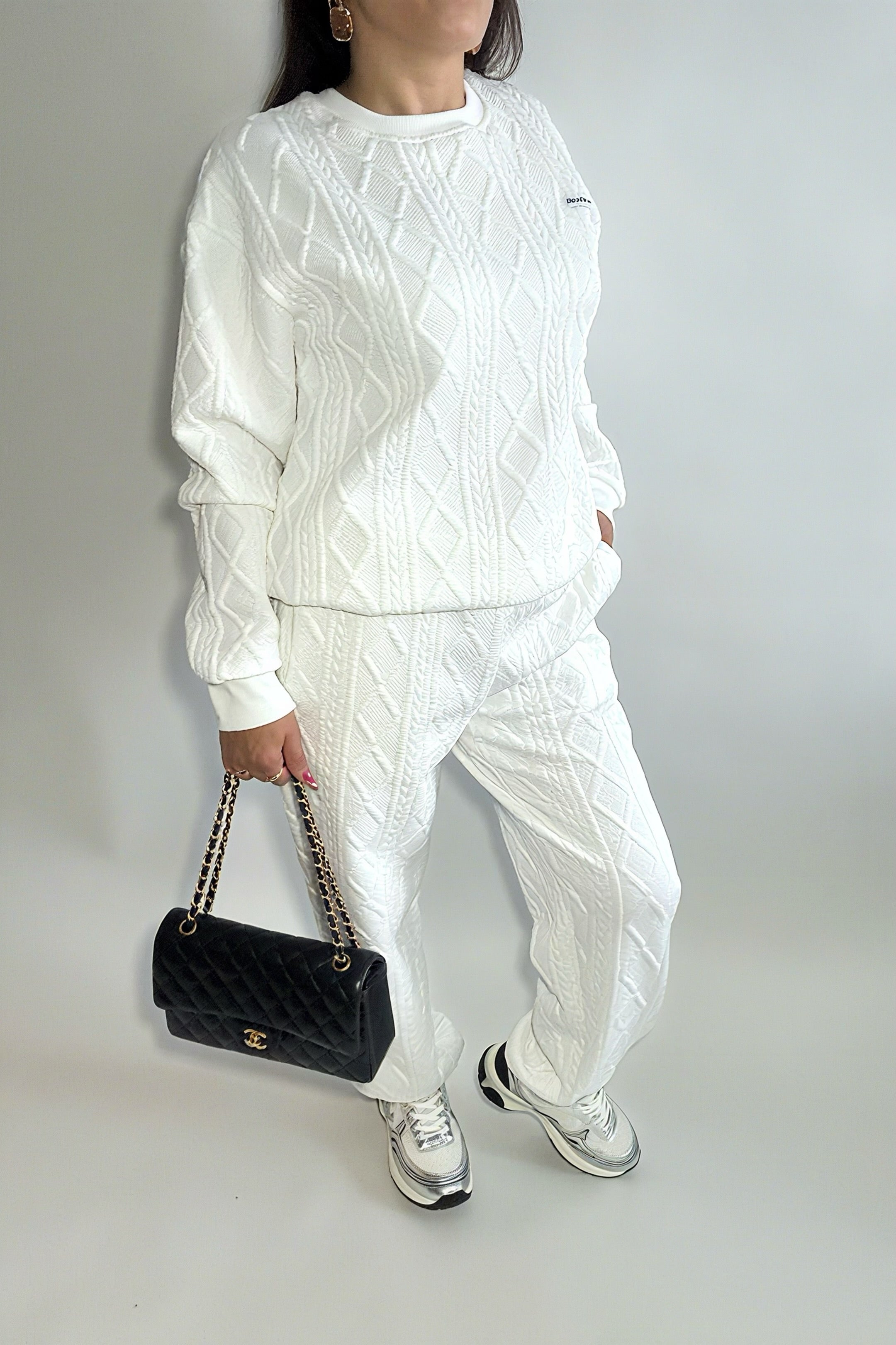 Ensemble femme 2 pièces composé d’un sweat-shirt texturé à manches longues et d’un pantalon assorti, disponible en blanc et noir, style décontracté et élégant.