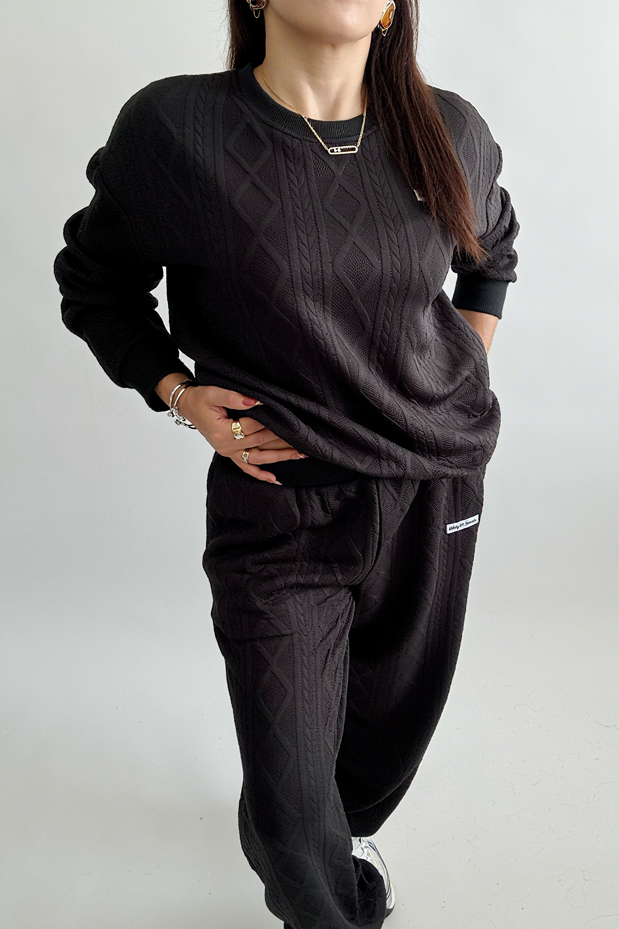 Ensemble femme 2 pièces composé d’un sweat-shirt texturé à manches longues et d’un pantalon assorti, disponible en blanc et noir, style décontracté et élégant.